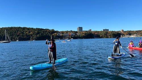Paddlers dressed as witches are pictured on the water.