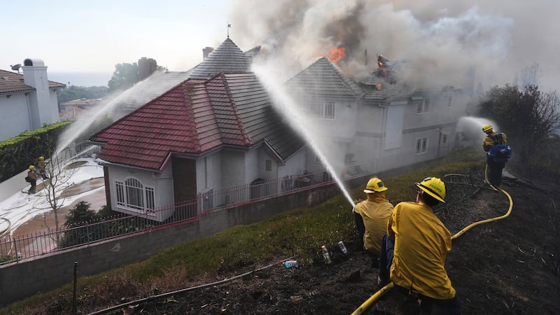 Multiple Southern California homes are ablaze in a fast-moving wildfire fuelled by hot wind