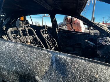 Plant employee Jessica Thompson examines the remains of her burnt car. (CTV Atlantic / Jonathan MacInnis)