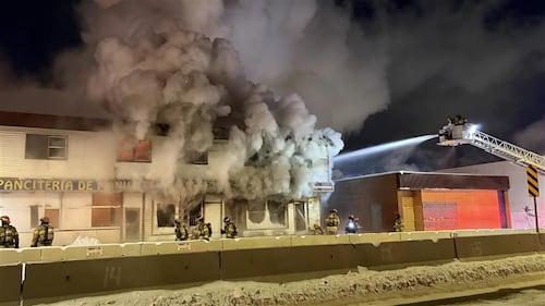 Firefighters on ladder trucks spray water on a fire at the former Jasper Place Hotel along Stony Plain Road in Edmonton the early morning of Feb. 19, 2026. (Sean McClune / CTV News Edmonton)