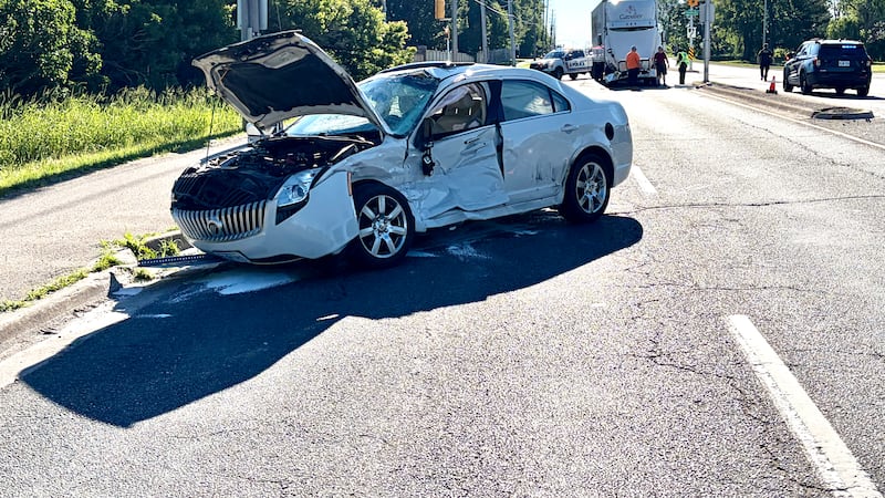 Sedan crosses median after collision with transport truck